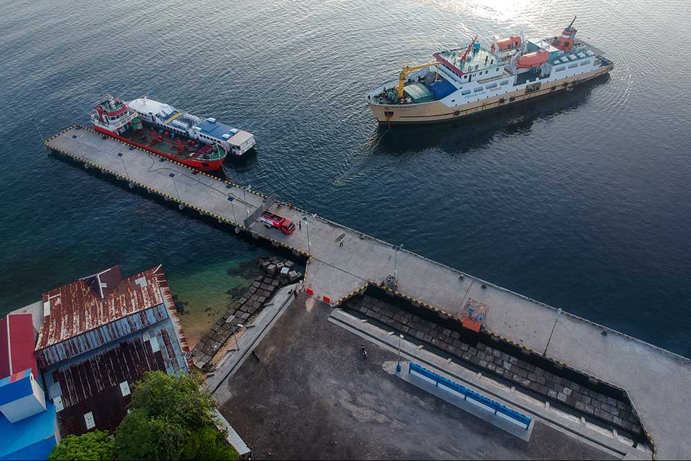 Perahu dan kapal kayu bersandar di dermaga pelabuhan tua saat senja
